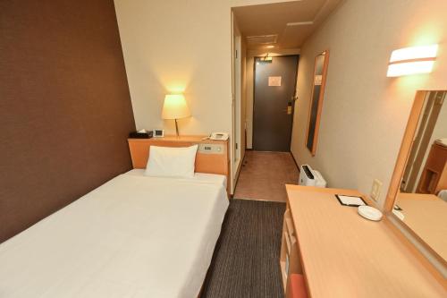 a hotel room with a bed and a desk at Sanco Inn Kuwana Ekimae in Kuwana