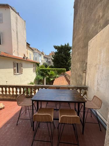 une table et des chaises sur un balcon avec vue dans l'établissement #101-Heart of Vieil Antibes - Place Nationale-High-End Newly Renovated & Furnished Appartment, à Antibes