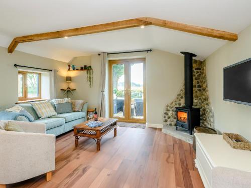 a living room with a couch and a fireplace at Stackyard Cottage in Felmingham