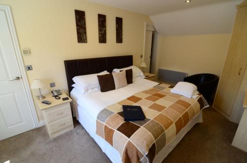 a bedroom with a bed with a laptop on it at Ellerby Country Inn in Ellerby