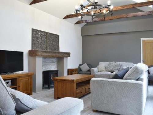 ein Wohnzimmer mit Sofa und Fernseher in der Unterkunft The Cottage in Bewdley