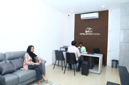 a group of people sitting at a table in a room at Erica Hotel International in Perintalmanna