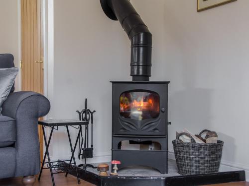 a wood stove in a living room with a couch at The Coach House - Ukc2772 in Sandwich