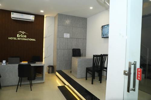 a waiting room with a table and chairs at Erica Hotel International in Perintalmanna