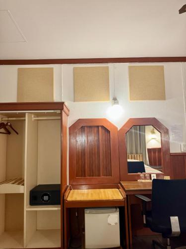 a room with a desk and a mirror in a room at Buakao Inn in Thongsala