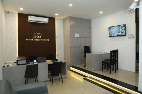 a lobby of a hotel with a reception desk and chairs at Erica Hotel International in Perintalmanna