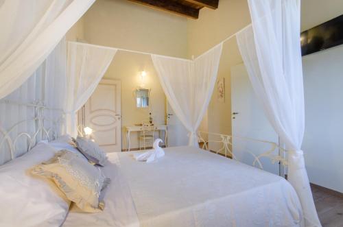 a bedroom with a white bed with a canopy at Agriturismo Tenuta Umberto I in Ripacorbaria