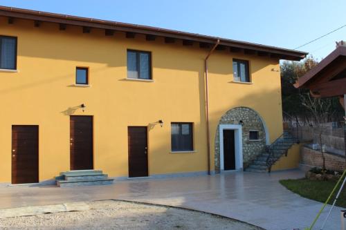 a yellow house with two doors and a courtyard at Agriturismo Tenuta Umberto I in Ripacorbaria