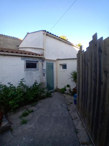 une clôture devant une maison blanche avec une porte bleue dans l'établissement Studio 34, à Bourcefranc