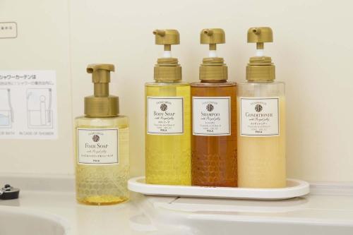 a group of four bottles of oils on a shelf at Sanco Inn Kuwana Ekimae in Kuwana