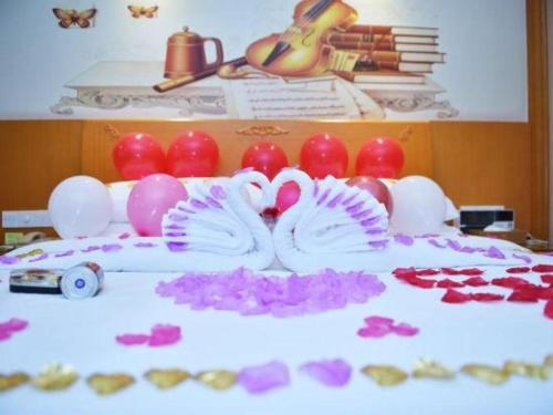 a table topped with purple and pink flowers and balloons at Vienna Hotel Shenzhen Bao'an Airport Taoyuanju Pingluanshan Metro Station in Shenzhen