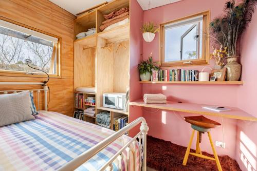 a bedroom with a bed and a desk and a window at Timber & Stone - Sanctuary Eco Studio in Yapeen