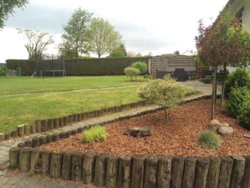a garden with a retaining wall and a yard at Eifelhaus Emmels in Saint-Vith