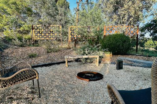 a garden with a fire pit and a bench at Timber & Stone - Sanctuary Eco Studio in Yapeen