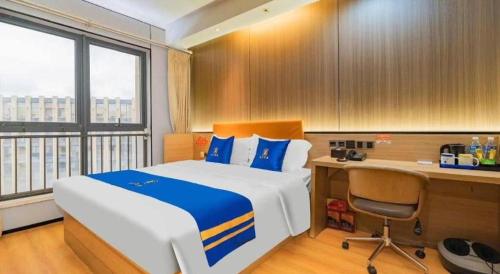 a bedroom with a bed and a desk and a computer at IU Hotel Chengdu High-Tech Zone Longhu Times Street in Chengdu
