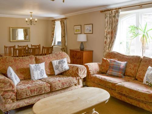 a living room with two couches and a table at The Mill House in Warenford