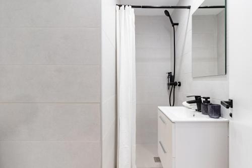 a white bathroom with a shower and a sink at Arena One Studio in Fuengirola