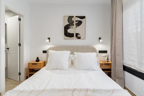 a bedroom with a large white bed with white pillows at Arena One Studio in Fuengirola