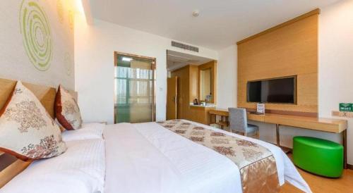 a bedroom with a bed and a desk with a television at GreenTree Inn Nantong University Industrial Expo City Express Hotel in Nantong