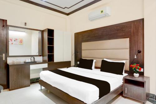 a bedroom with a large bed and a sink at Super Townhouse Sushant Lok Phase 1 Formerly Hotel Neven in Gurgaon