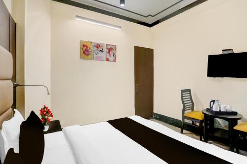 a hotel room with a bed and a table and a television at Super Townhouse Sushant Lok Phase 1 Formerly Hotel Neven in Gurgaon