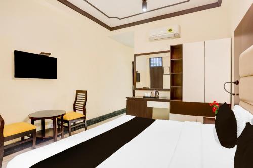 a hotel room with a bed and a table and chairs at Super Townhouse Sushant Lok Phase 1 Formerly Hotel Neven in Gurgaon