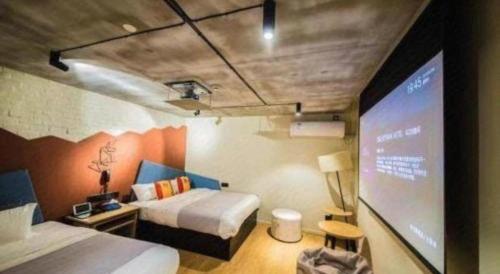 a room with two beds and a projection screen at YUNIK-Shanghai Zhongshan Park Yan'an Xi Road in Shanghai
