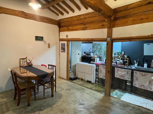 a dining room with a table and a kitchen at Alleyway 모퉁이 in Jeonju