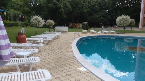 een zwembad met witte ligstoelen en een stapel handdoeken bij Luxury Sunrise Complex Apartment in Goudstrand