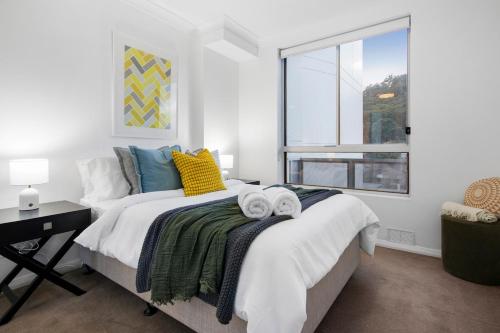 a bedroom with a bed with towels on it at Two-Story Penthouse Apartment in Gosford