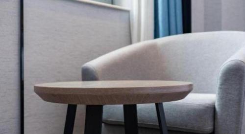 a wooden coffee table sitting next to a chair at Nanning Prince Hotel in Nanning