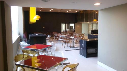 a restaurant with tables and chairs and a kitchen at Keys Select by Lemon Tree Hotels, Visakhapatnam in Visakhapatnam