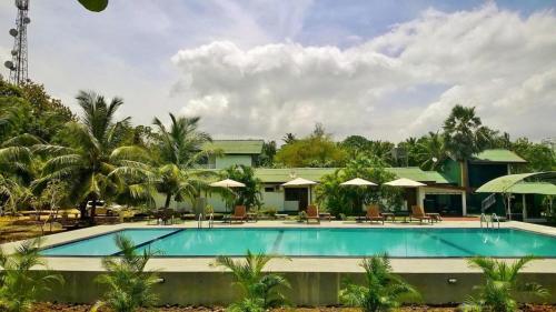 ein Swimmingpool vor einem Ferienresort in der Unterkunft Saji-Sami Hotel in Anuradhapura
