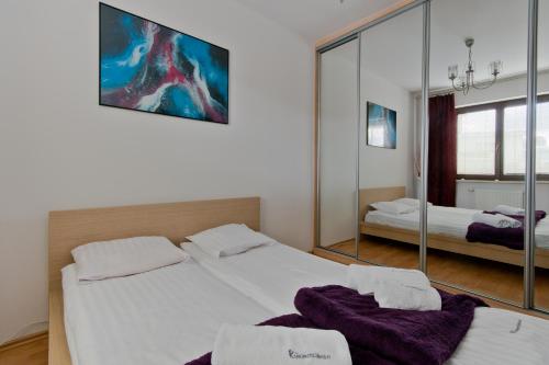 グダニスクにあるApartamenty Gdańsk EU - Apartament Jelitkowskiのベッドルーム1室(ベッド2台、大きな鏡付)