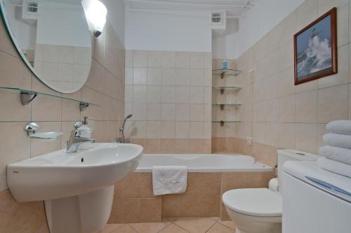 グダニスクにあるApartamenty Gdańsk EU - Apartament Jelitkowskiのバスルーム(シンク、バスタブ、トイレ付)