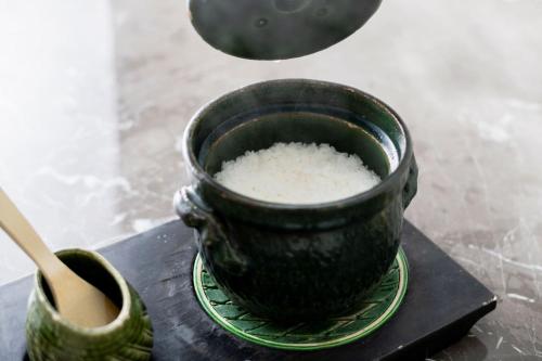 a black pot of rice on a plate with a spoon at River Retreat Garaku in Toyama