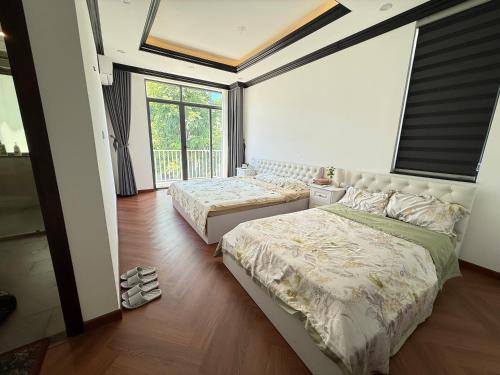 Un dormitorio con dos camas y una ventana. en Ana La Vie Hue, en Thôn Lại Thê