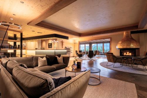 a living room with a couch and a fireplace at Das Kaltenbach - ApartHotel in Kaltenbach