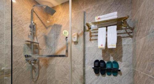 a bathroom with a shower with a glass door at Zhangjiajie Xiangfu International Hot Springs Hotel in Zhangjiajie