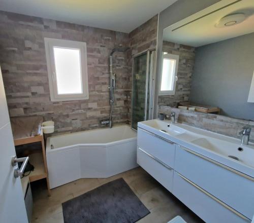 LéguevinにあるVilla entière avec piscine- 8pの白い浴槽と洗面台のあるバスルーム