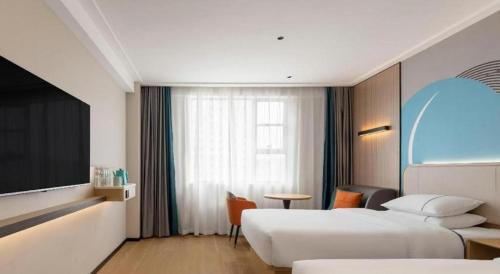 a hotel room with two beds and a tv at City Comfort Inn Wuhan Hankou Railway Station West Square in Wuhan