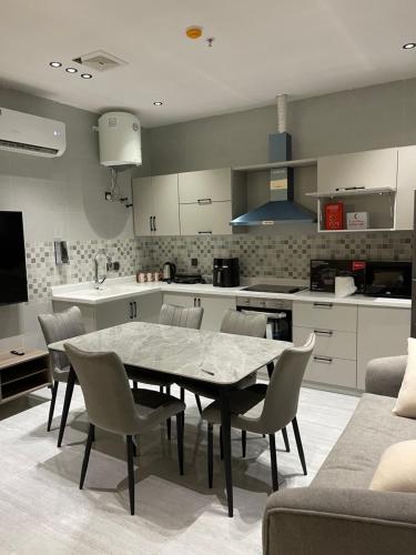 a kitchen with a table and chairs in a room at شقق في الحمرا هاي رايز in Al Khobar