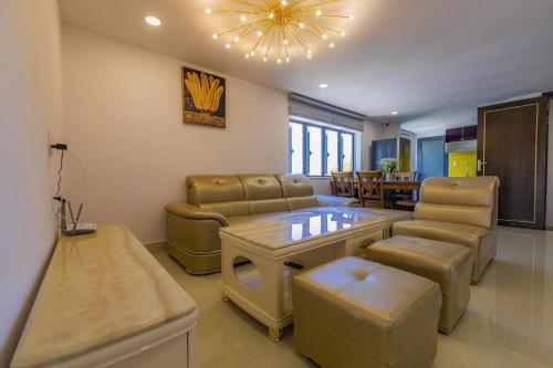 a living room with a couch and a table and chairs at Khanh Uyen 1 Hotel in Da Lat