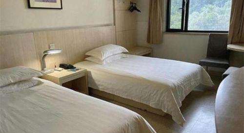 a hotel room with two beds and a window at Jinjiang Inn Wuhu High-Speed Railway Station West Square in Wuhu