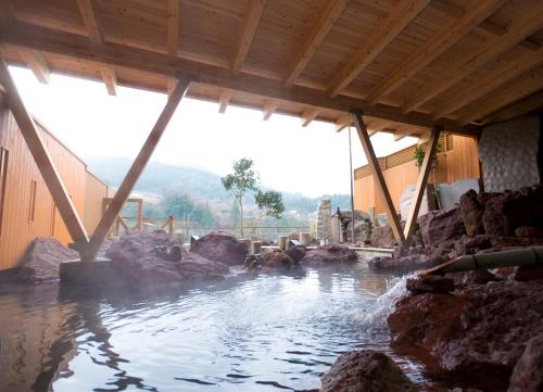 a pool of water with rocks in a building at River Retreat Garaku in Toyama