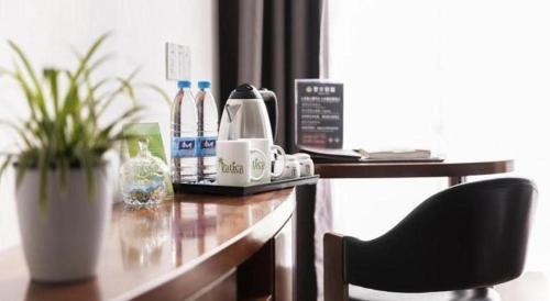 a desk with a chair and a coffee maker on it at Vatica Shanghai Jiading District Anting Metro Station Moyu Road Hotel in Shanghai