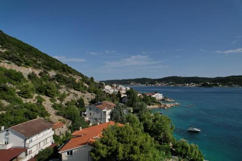 een stad op een heuvel naast een waterlichaam bij Matteo in Supetarska Draga