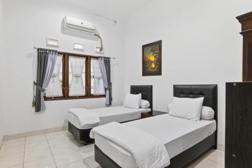 a room with two beds and a window at Shafira House - Modern House 3BR near Yogyakarta culinary spots in Ngaglik