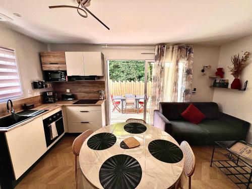 eine Küche und ein Esszimmer mit Tisch und Sofa in der Unterkunft Sweet Home Two in Saint-Jean-de-Monts