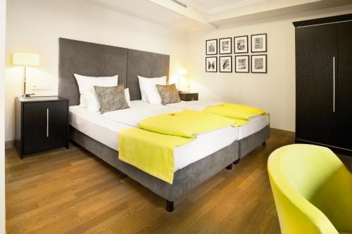 a bedroom with a large bed with yellow sheets at Hotel Hamburger Hof in Frankfurt/Main